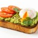 avocado toast with poached egg and tomato slices isolated on white background